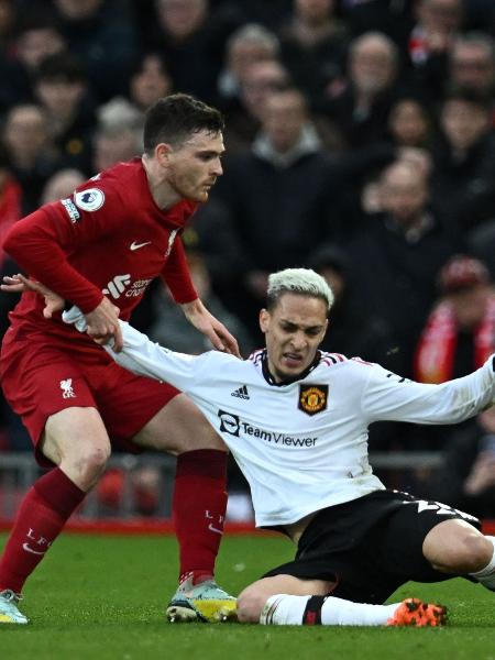 Antony, do Manchester United, é puxado por Andy Robertson, do Liverpool. - PAUL ELLIS/AFP