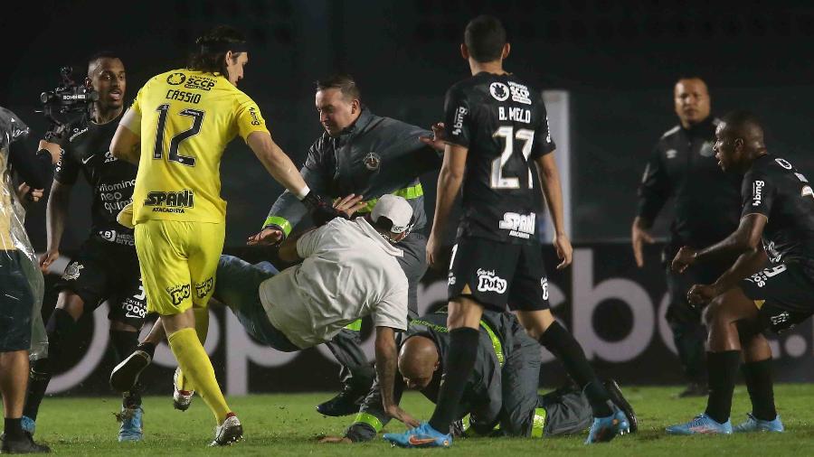 Torcedor do Santos (de camisa branca) caiu no gramado após agredir Cássio, goleiro do Corinthians, em jogo entre as equipes na Vila Belmiro - GUILHERME DIONíZIO/CÓDIGO19/ESTADÃO CONTEÚDO
