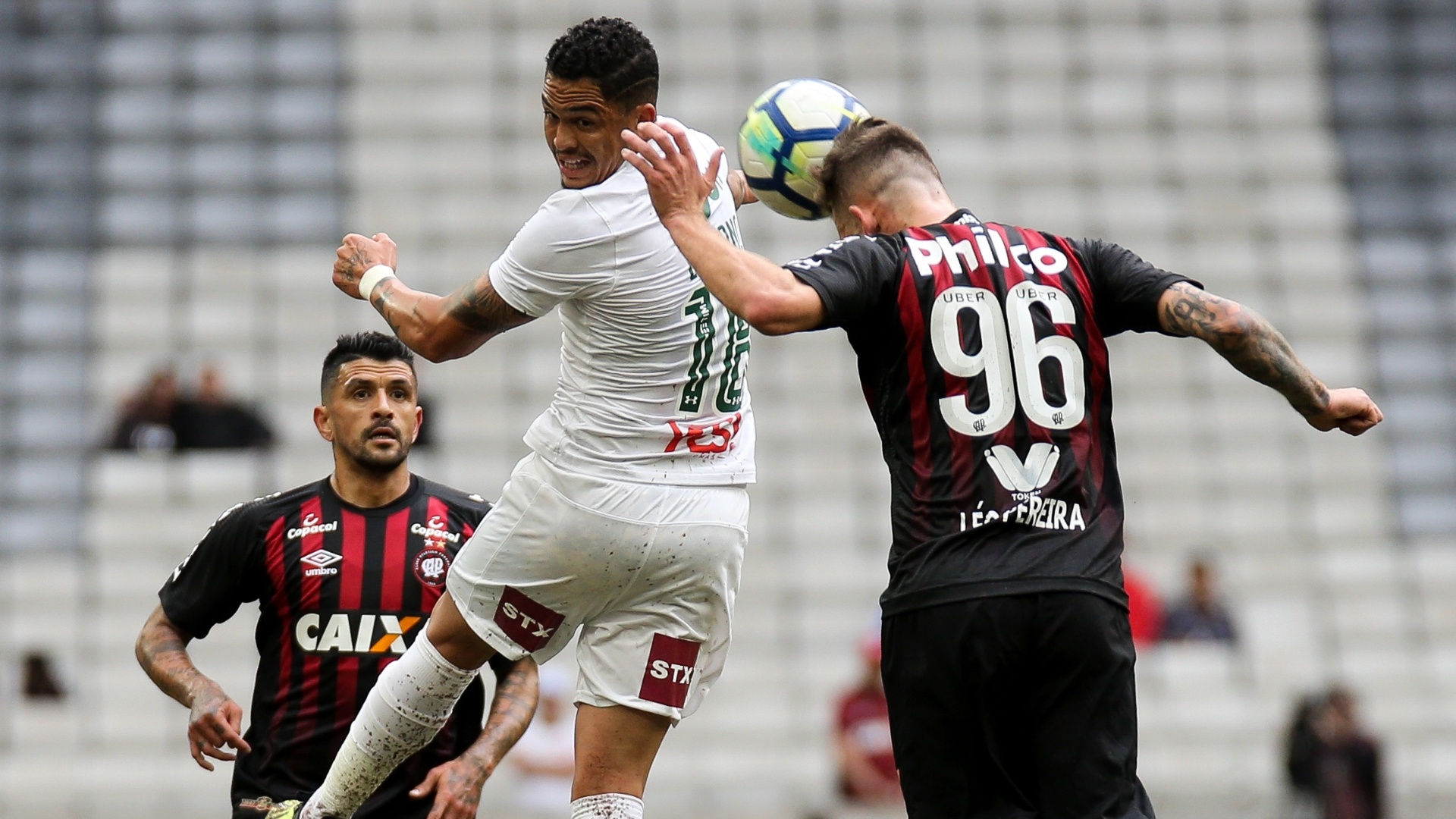 Luciano e Léo Pereira disputam a bola pelo alto no jogo entre Atlético-PR e Fluminense
