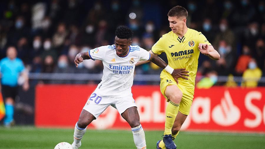 Vinicius Jr disputa a bola com Juan Foyth, durante a partida entre Real Madrid e Villarreal - Aitor Alcalde/Getty Images