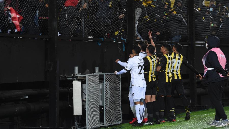 Jogadores de Peñarol e Colón tentam acalmar torcedores em jogo pela Copa Libertadores - PABLO PORCIUNCULA / AFP