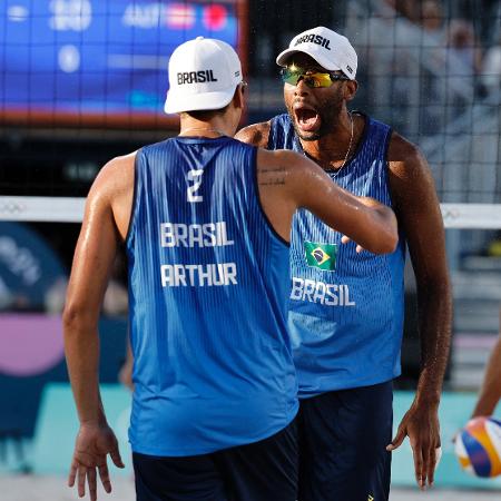 Evandro e Arthur, dupla brasileira do vôlei de praia, celebra ponto sobre austríacos em jogo das Olimpíadas