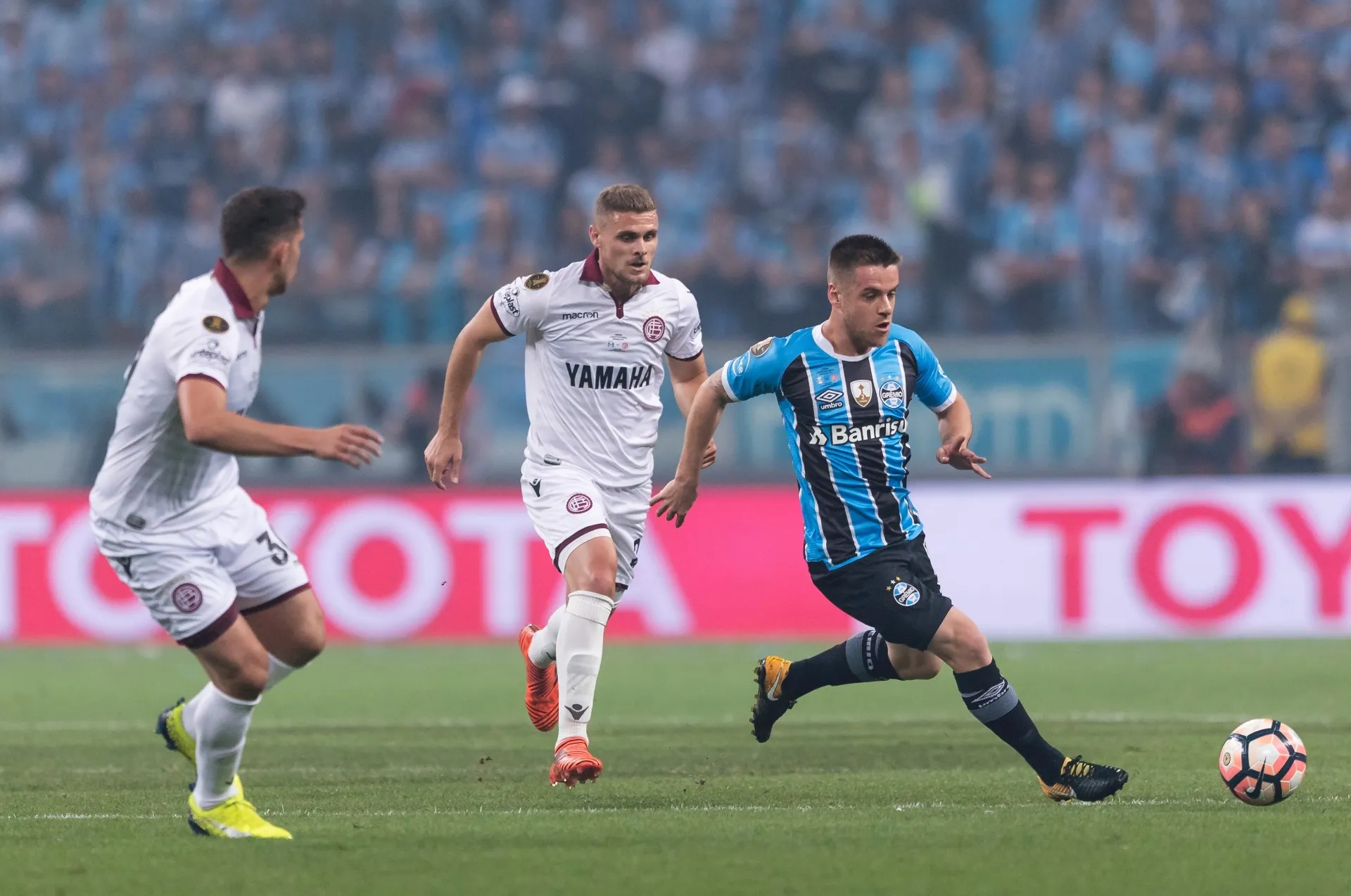 Ramiro foge da marcação do Lanús no primeiro jogo da final da Libertadores, na Arena do Grêmio - undefined