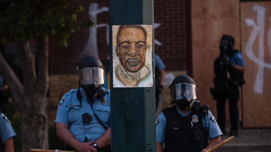 Policiais se posicionam ao lado de poste com desenho de George Floyd - Stephen Maturen/Getty Images