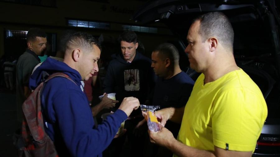 Thiago Neves distribui comida para moradores de rua ao lado de agentes - Divulgação 