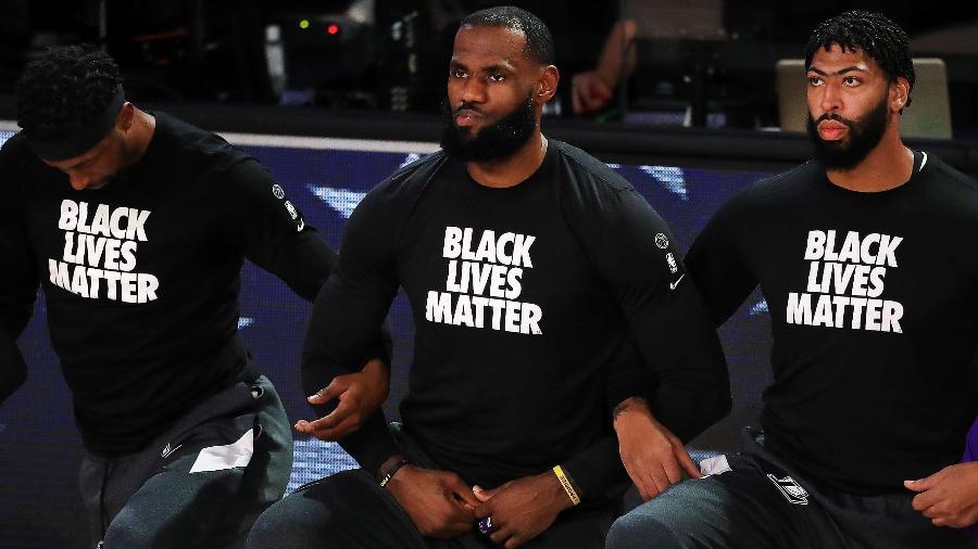 LeBron James (ao centro) se ajoelha durante execução do hino nacional americano em protesto antirracista - Mike Ehrmann/Getty Images/AFP