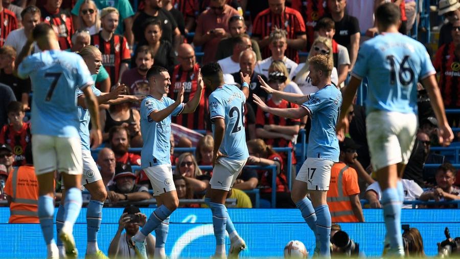 Jogadores comemoram terceiro gol do City sobre o Bournemouth pelo Campeonato Inglês - Oli SCARFF / AFP
