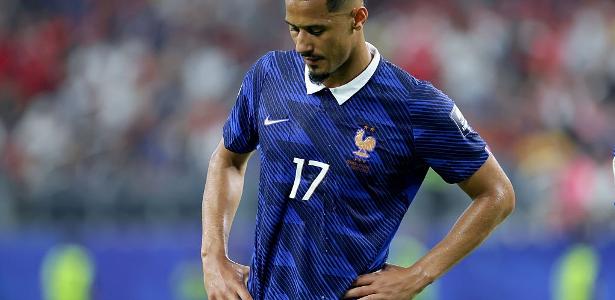 A lone French football jersey hangs on a locker in a dimly lit, dramatic setting, symbolizing resilience and hidden battles.