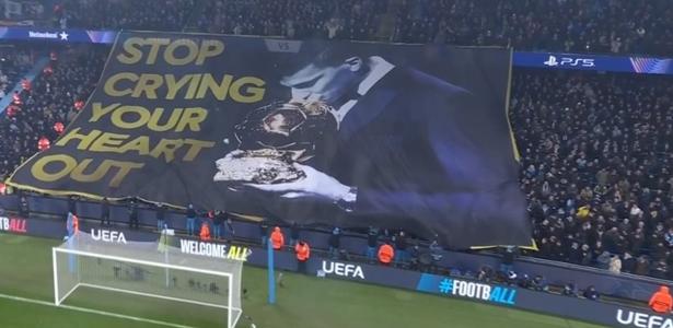 Torcida do City provoca Vini Jr com bandeira de Rodri beijando Bola de Ouro