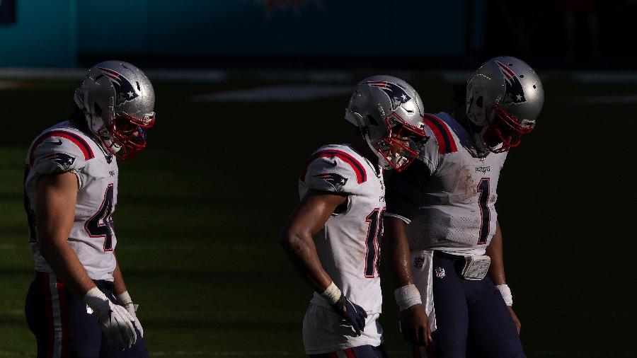 Jogadores do New England Patriots deixam o campo cabisbaixos após eliminação da equipe na temporada da NFL - Mark Brown/Getty Images/AFP