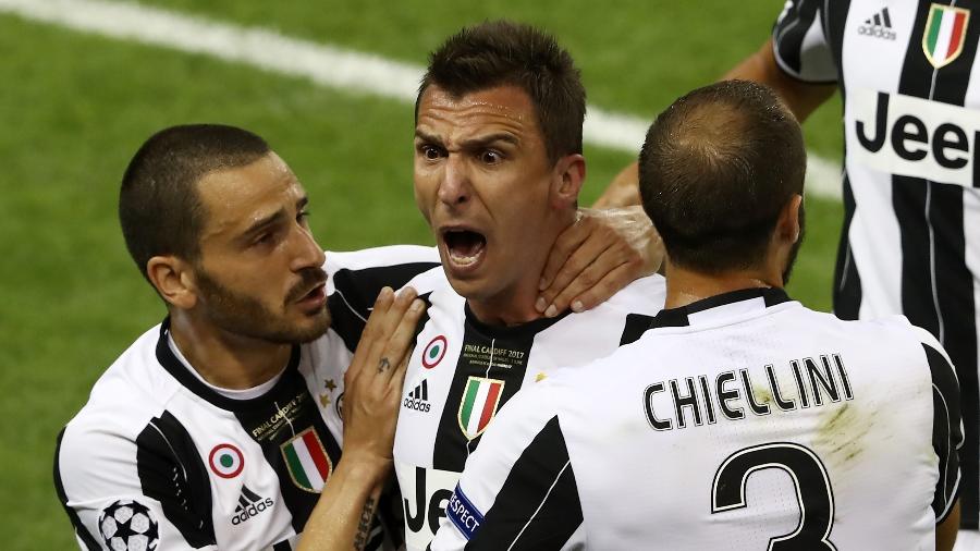 Chiellini (direita) abraça Mandzukic (centro) em jogo da Juventus - Alexander Hassenstein - UEFA/UEFA via Getty Images