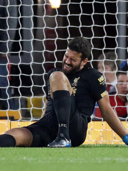 Alisson fica no chão reclamando de dores, durante a partida entre Liverpool e Norwich - Reuters/Carl Recine