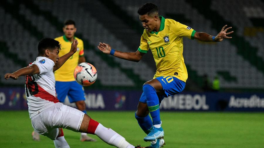 Pedrinho tenta escapar da marcação do peruano José Rivera em jogo pelo Pré-Olímpico na Colômbia - Juan BARRETO / AFP