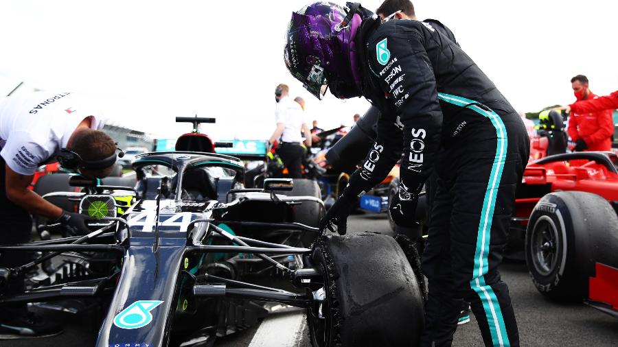 Lewis Hamilton checa o pneu estourado de sua Mercedes após vencer o GP da Inglaterra em Silverstone - Bryn Lennon/Getty Images