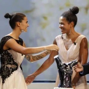 A alemã Celia Sasic (centro) recebe o abraço da compatriota Dzsenifer Marozsan após ser eleita a melhor jogadora da Europa, em Mônaco; Marozsan ficou em segundo - VALERY HACHE/AFP