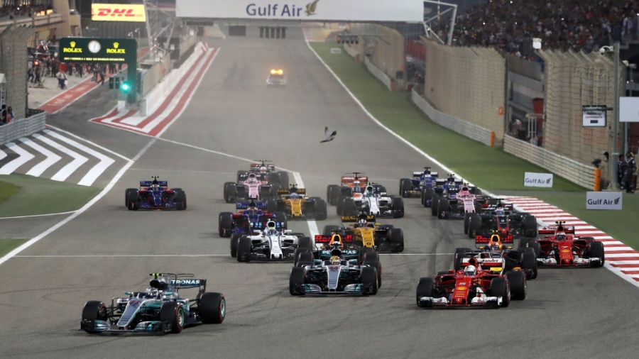 Largada do GP do Bahrein, com Vettel, à direita na foto, ultrapassando Lewis Hamilton - AFP PHOTO / Karim Sahib