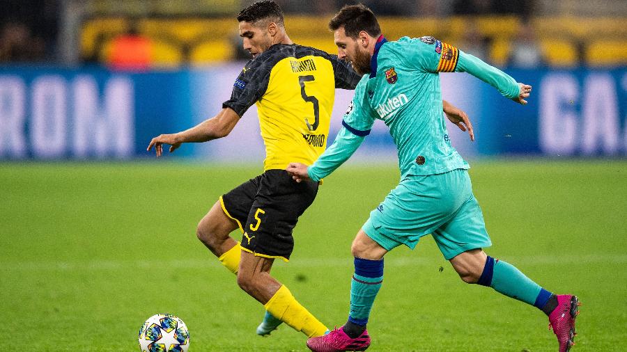Lionel Messi disputa a bola com Hakimi em Borussia Dortmund x Barcelona - Marius Becker/picture alliance via Getty Images