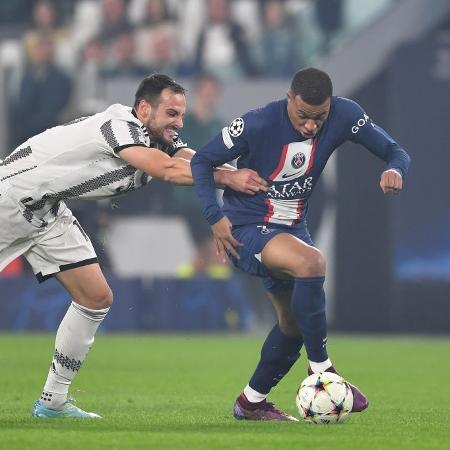 Mbappé, do PSG, sendo segurado por jogador da Juventus na partida válida pela 6ª rodada da Liga dos Campeões - Valerio Pennicino/Getty