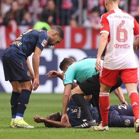 O árbitro Patrick Ittrich ajuda Josuha Guilavogu, do Mainz, durante a partida da Bundesliga 