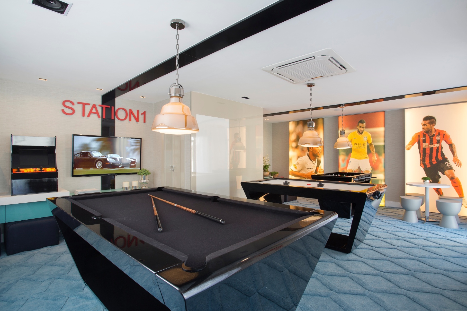 O salão de jogos da casa de Alex Teixeira tem referência à carreira do atleta com fotos nas paredes. A mesa de sinuca com design contemporâneo se destaca no local - Divulgação