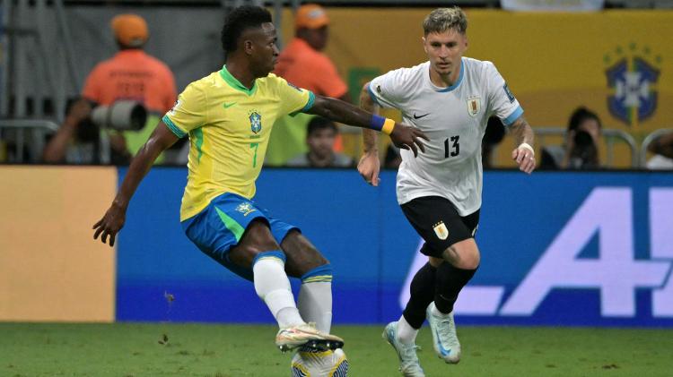 Vini Jr e Varela em ação durante jogo entre Brasil e Uruguai pelas Eliminatórias