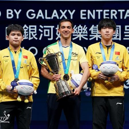 Hugo Calderano com o troféu da Copa do Mundo de Tênis de Mesa, ao lado dos chineses - ITTF