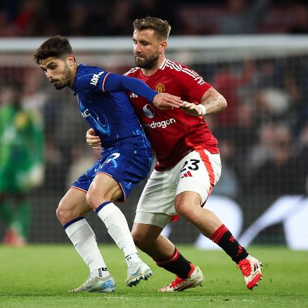 Pedro Neto, do Chelsea, disputa bola com Luke Shaw, do Manchester United, em jogo do Campeonato Inglês - HENRY NICHOLLS / AFP