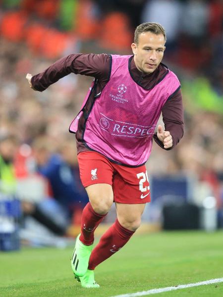 Arthur aquece para entrar em partida do Liverpool na Liga dos Campeões. - LINDSEY PARNABY/AFP