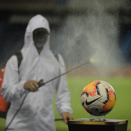 Funcionário desinfecta bola antes de jogo do Santos na Copa Libertadores 2020 - Raul ARBOLEDA / AFP