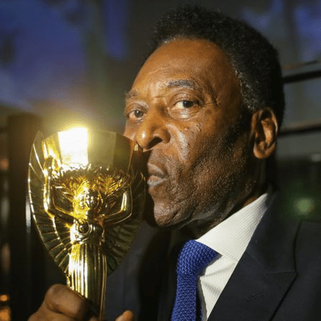 No Museu da Seleção Brasileira, Pelé beija réplica da taça Jules Rimet, conquistada pelo Brasil na Copa do Mundo de 1970, no México - Divulgação/CBF