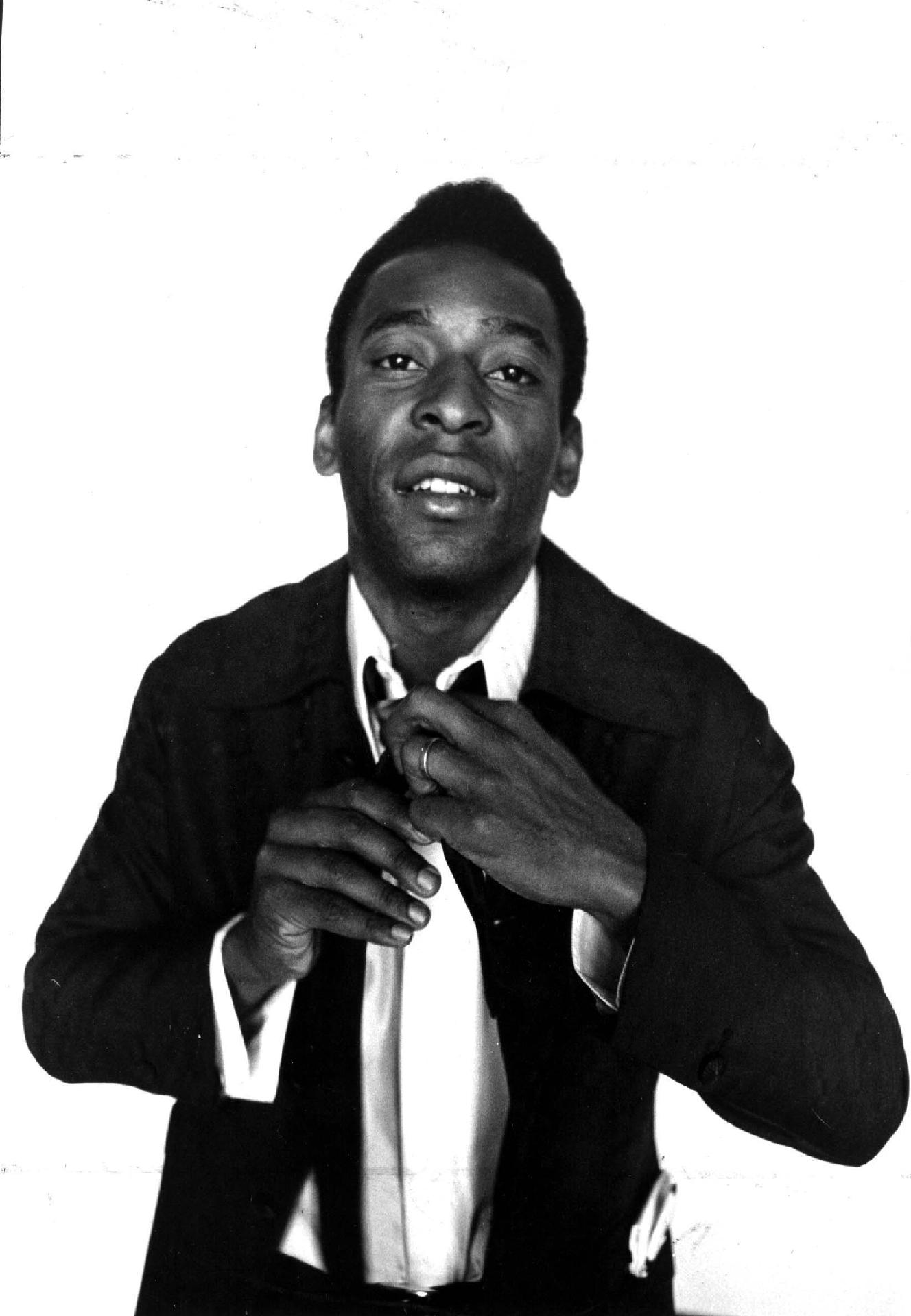 02/10/1974 - Na foto, Pelé arruma a gravata. Com um futebol vistoso dentro de campo, o craque também sempre se preocupou com a elegância fora dos gramados. - Domicio Pinheiro/Estadão Conteúdo