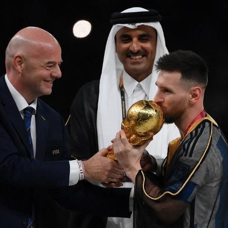 Á frente do emir Tamim bin Hamad bin Khalifa Al-Than, o presidente da Fifa entrega troféu da Copa do Mundo para Lionel Messi - FRANCK FIFE / AFP