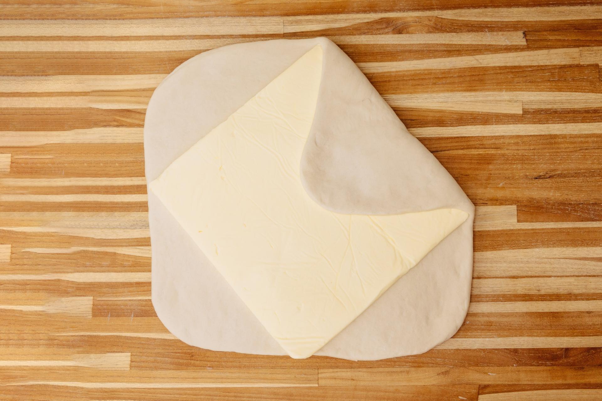 Após ser aberta em forma de quadrado, a massa é coberta por uma placa de manteiga gelada - são 700 gramas de manteiga para 2,1 quilos de massa. Fechada como um envelope, a massa vai de novo para a laminadora, processo que é repetido mais duas vezes, com intervalos de 40 minutos de descanso na geladeira - Michele Minerbo