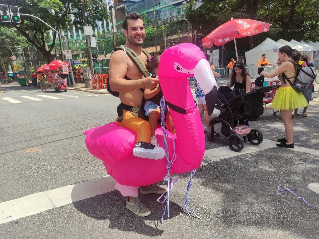 Engenheiro civil Felipe Trevisan fantasiado de flamingo inflável com a filha Sofia, de 2 anos - Martha Alves/UOL