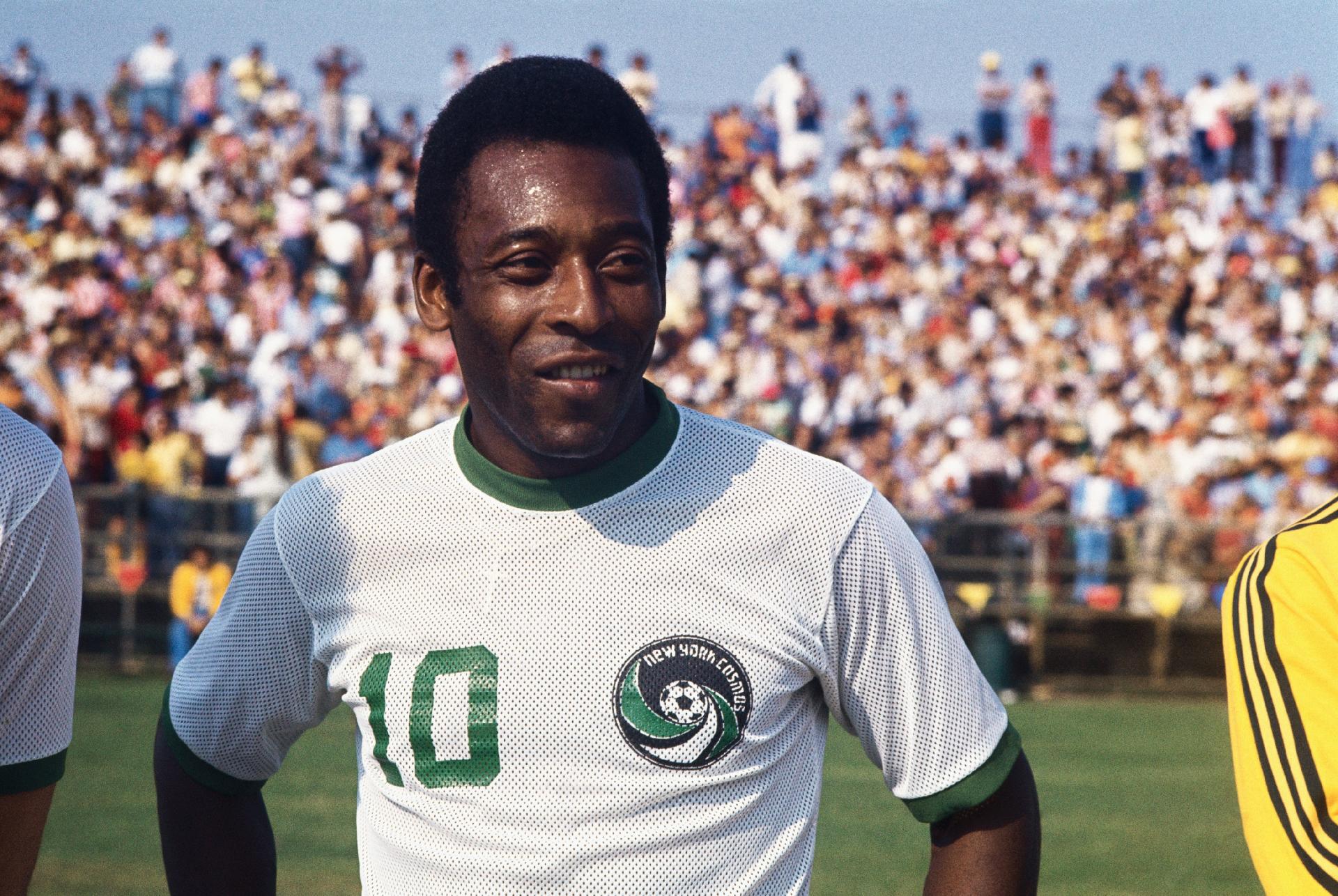 Retrato do rosto de Pelé na época em que o rei defendeu o NY Cosmos. Na imagem, o atleta está em pé no campo com o uniforme do clube norte-americano, com a multidão ao fundo. - Bettmann/Bettmann Archive