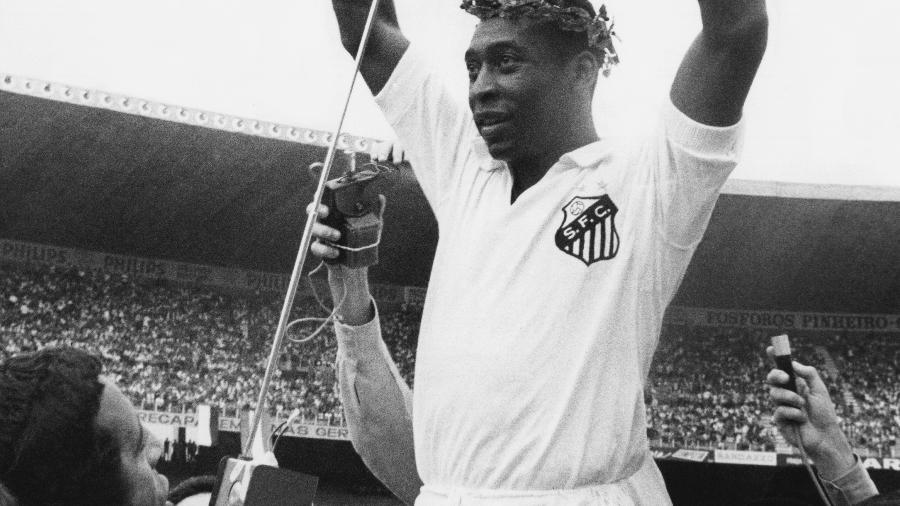 24.nov.1969 - Pelé usando uma coroa de flores enquanto comemorava com os demais jogadores do Santos FC. - Pictorial Parade