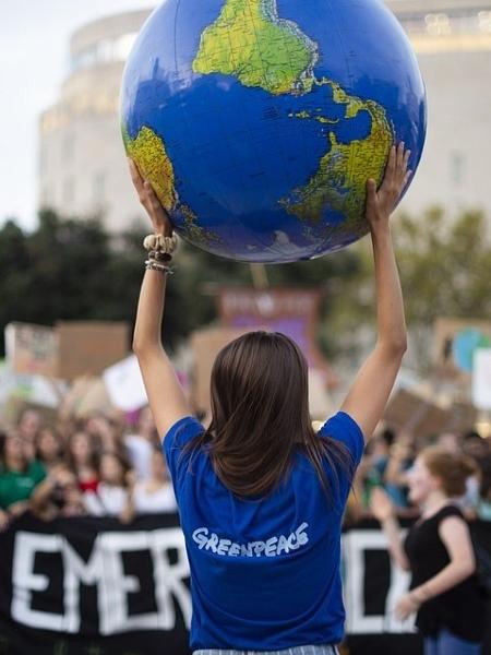 A foto, feita em Barcelona, na Espanha, mostra uma ativista do Greenpeace carregando uma réplica do planeta durante um protesto pelo clima. - @clau78/The World"s Best Photo of #Photojournalism2020