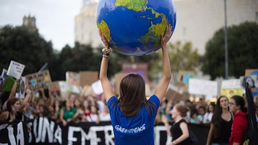 Ativista do Greenpeace carrega réplica do planeta durante um protesto pelo clima na Espanha - @clau78/The World"s Best Photo of #Photojournalism2020
