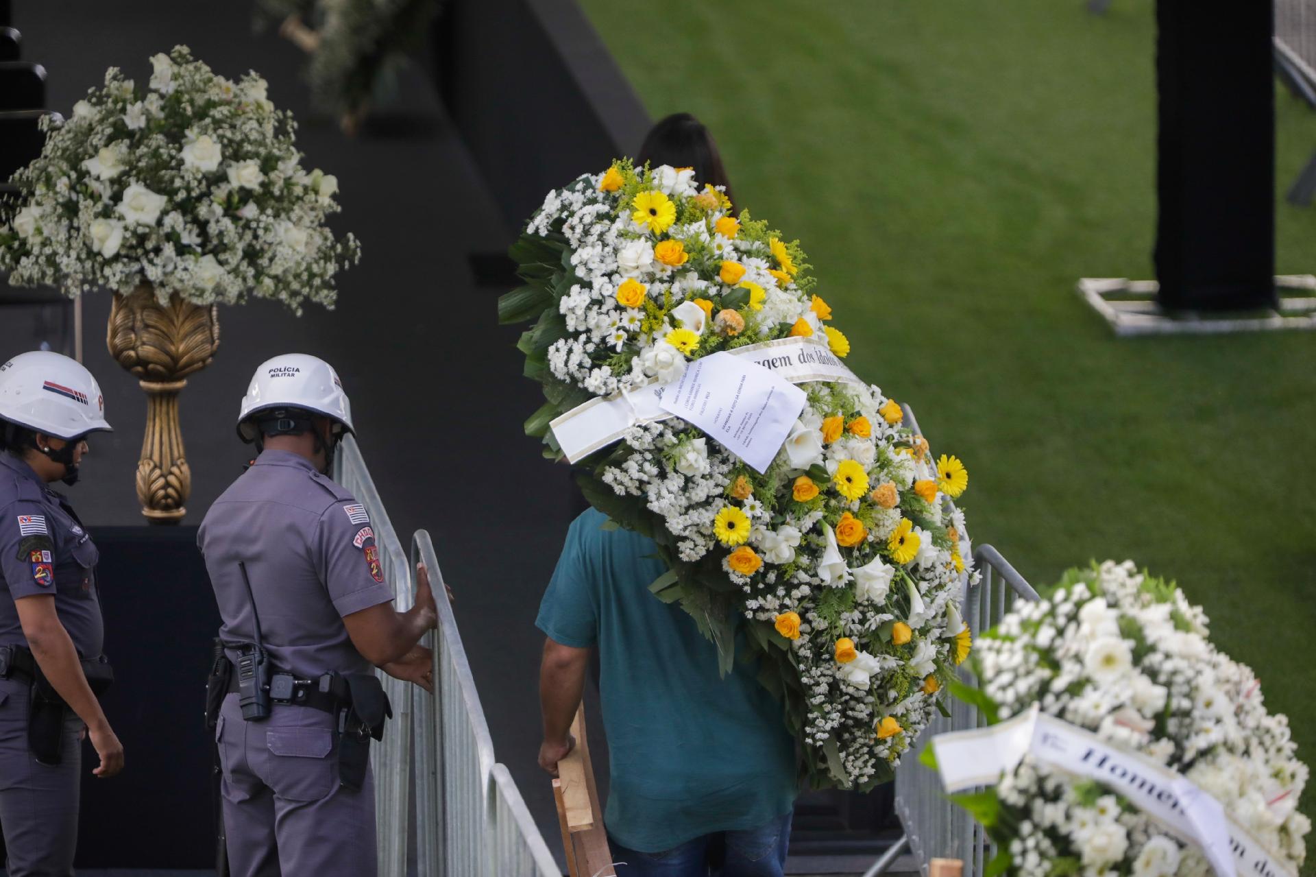 Officials carry wreaths to the middle of the lawn at Villa Belmero, where King Pele's sarcophagus will be - Marcelo Justo / UOL