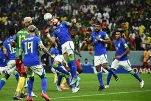 Alex Telles sobe de cabeça e na sequência sente lesão e precisou ser substituído no jogo entre Camarões e Brasil  - Jewel SAMAD / AFP