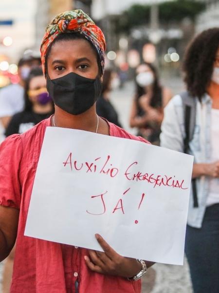 Manifestante pede auxílio emergencial em Curtiba (PR) - Joka Madruga