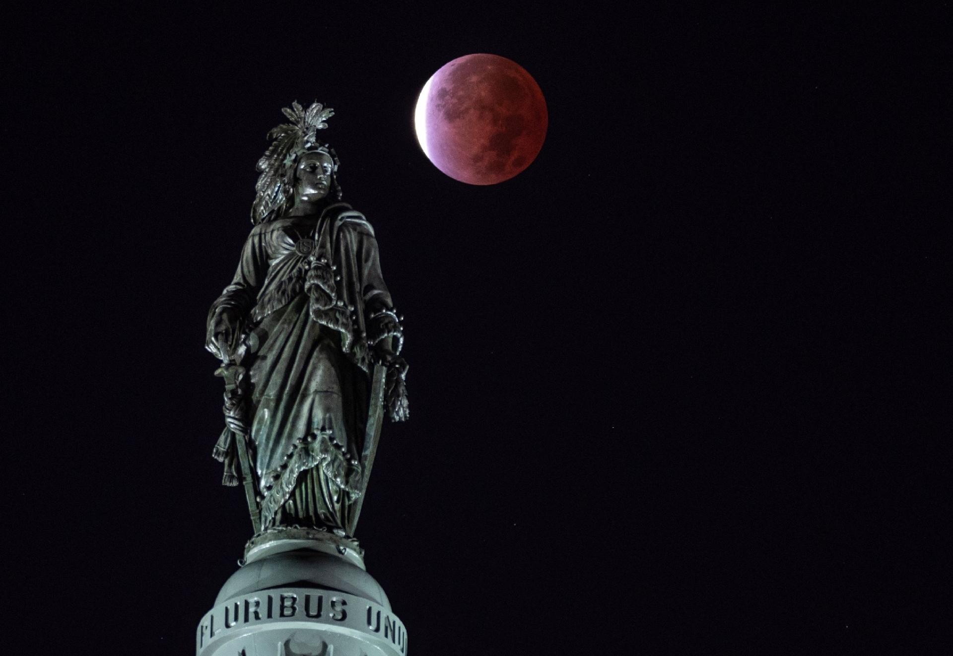 La luna, con un eclipse lunar parcial, detrás de la Estatua de la Libertad en Washington, DC (EE. UU.) - Andrew Caballero / AFP