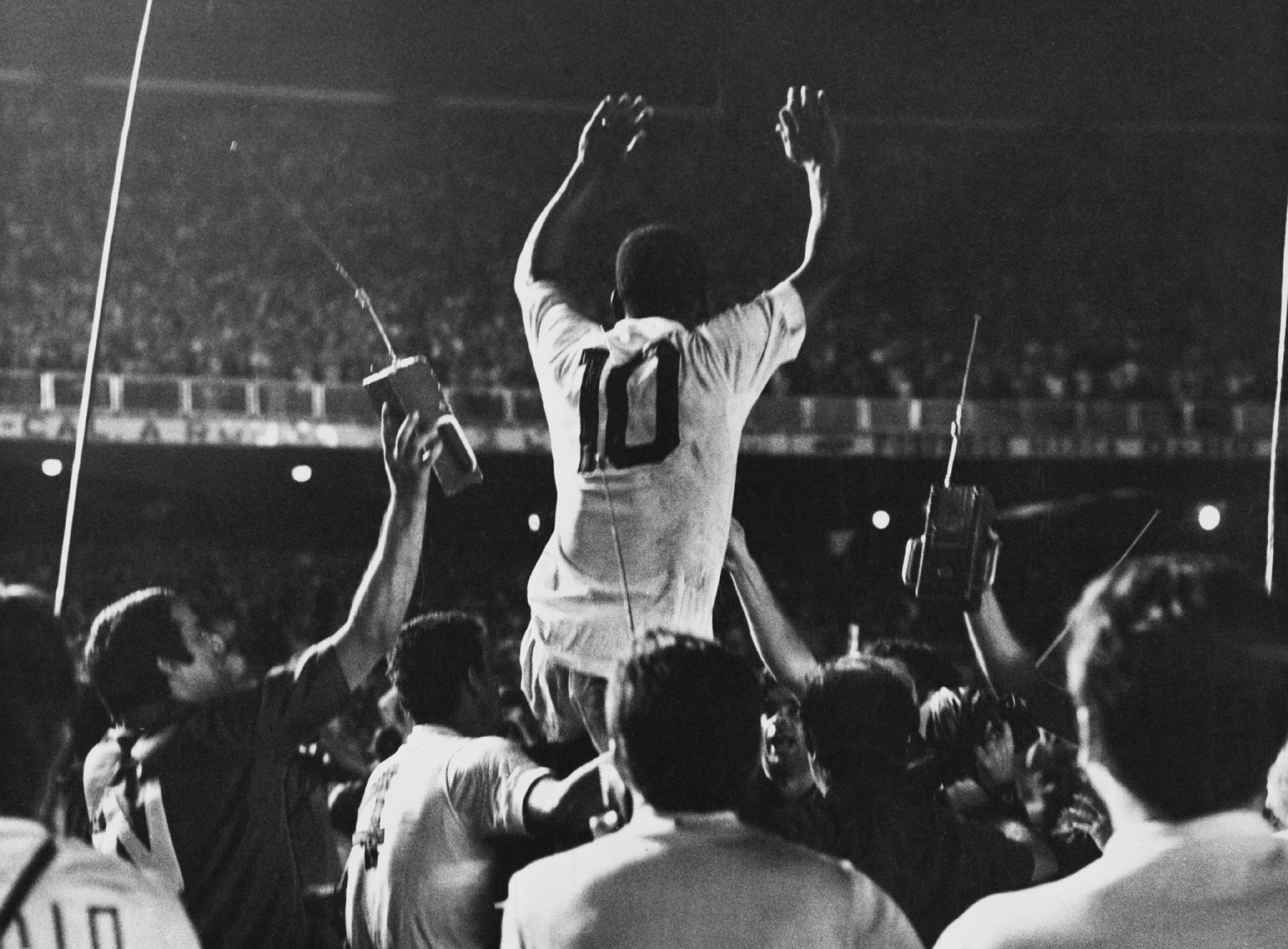 19.nov.1969 - Pelé é colocado nos ombros pelos companheiros de Santos após o marcar o milésimo gol de sua carreira em partida contra o Vasca da Gama no Maracanã. - Pictorial Parade