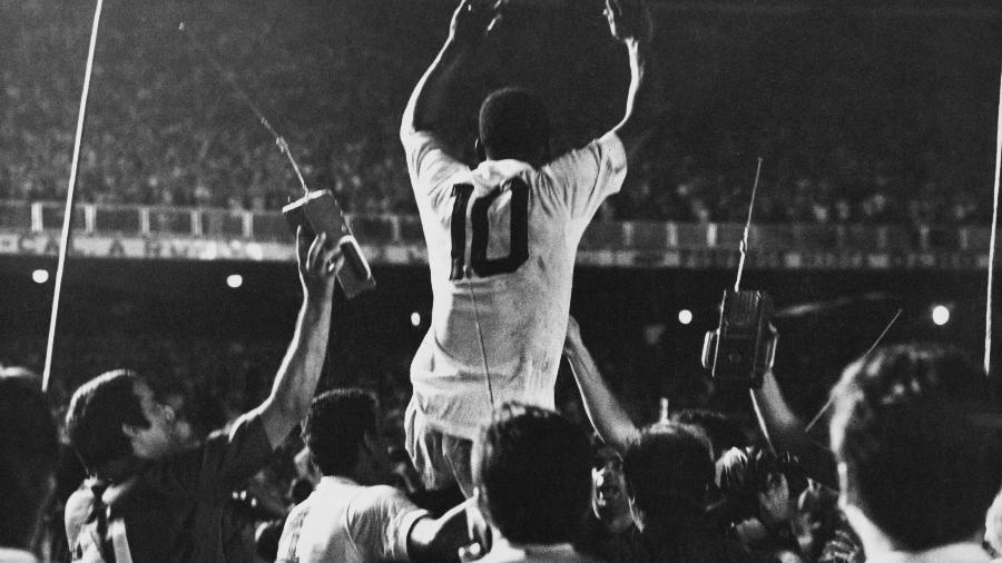 19.nov.1969 - Pelé é colocado nos ombros pelos companheiros de Santos após o marcar o milésimo gol de sua carreira em partida contra o Vasca da Gama no Maracanã. - Pictorial Parade