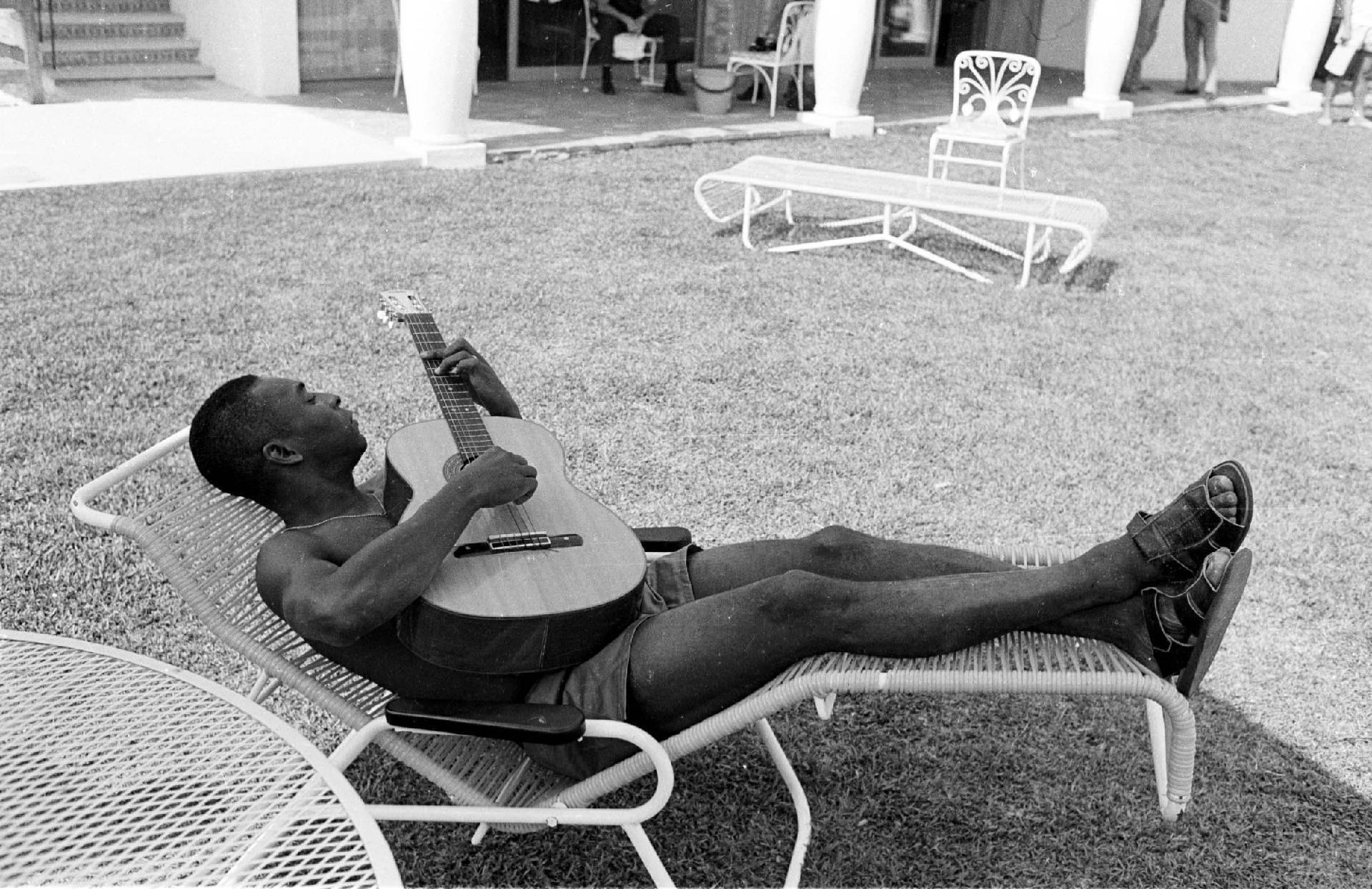 Pelé fotografado em um momento de descaso e lazer enquanto toca violão na década de 70. - Domicio Pinheiro/Estadão Conteúdo
