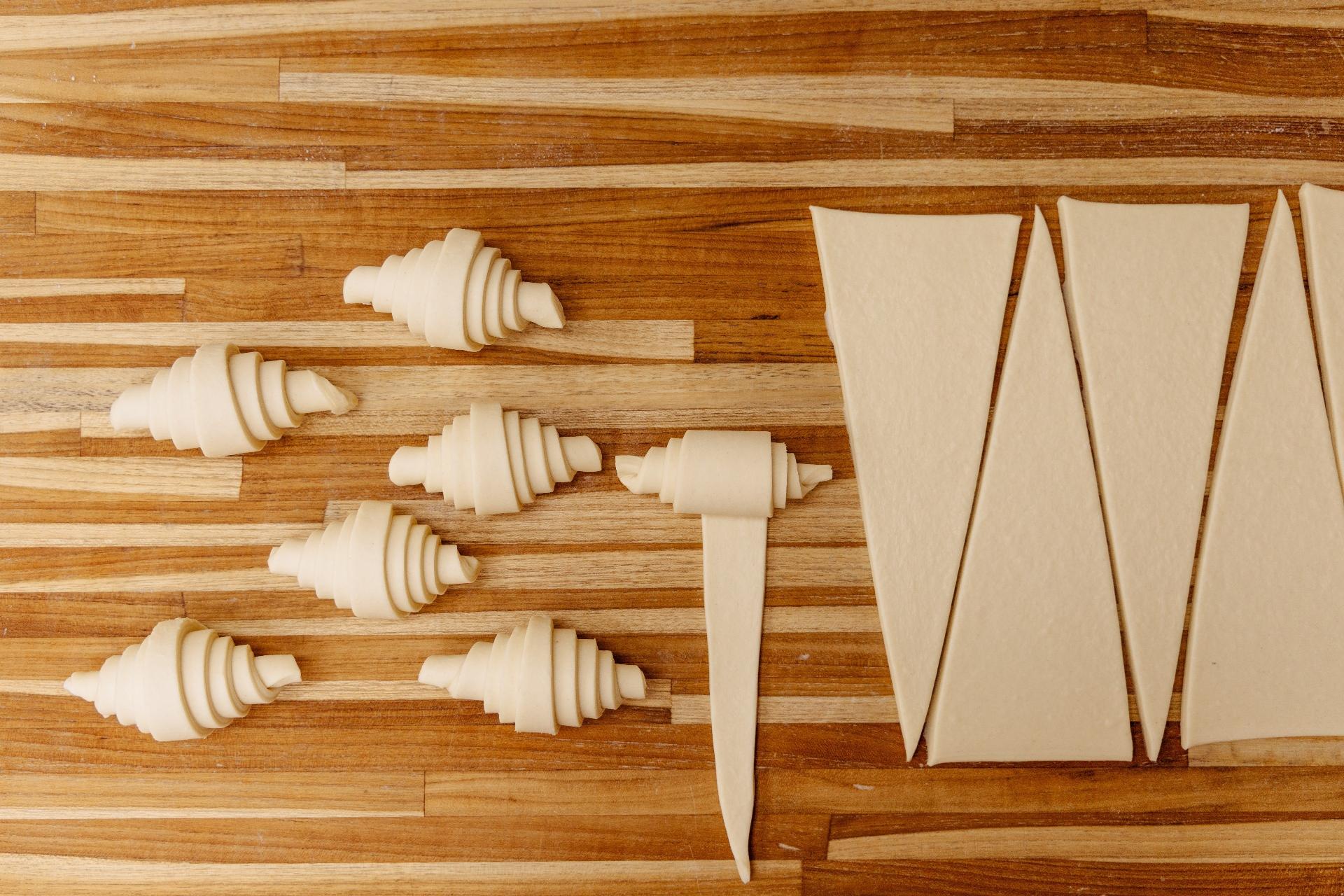 Aberta pela última vez, a massa vai para a mesa onde é cortada em triângulos. Enrolados, os croissants crus são pincelados com gela e leite e, já na assadeira, dormem na geladeira - Michele Minerbo