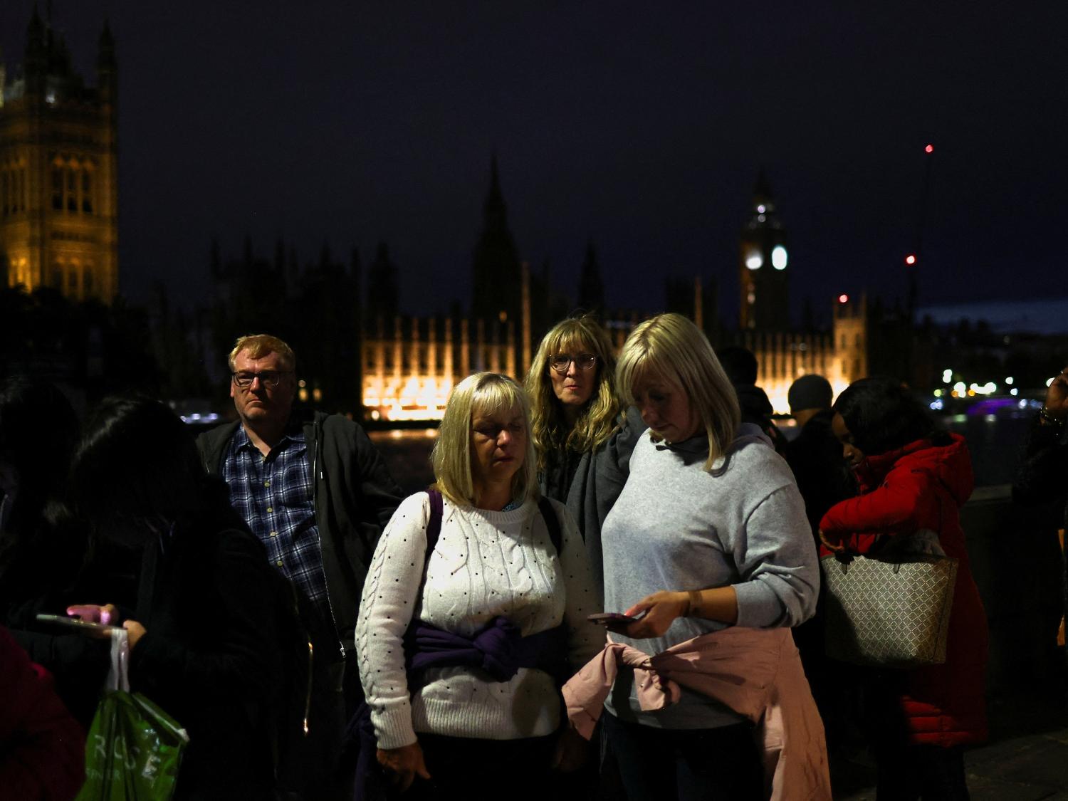 People pause during a "National moment of reflection" in honour of the late Queen Elizabeth II, the day before her funeral, in London, Britain, September 18, 2022. REUTERS/Tom Nicholson ORG XMIT: GDN - TOM NICHOLSON/REUTERS