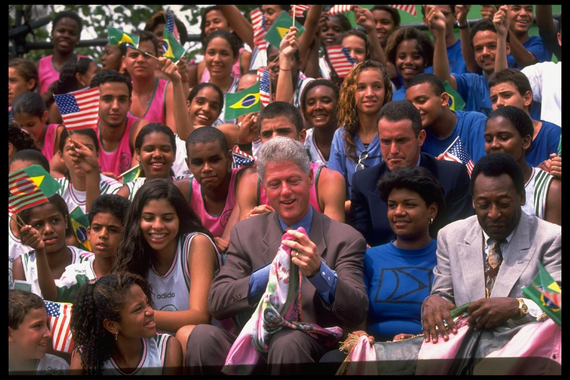 14.out.1997 - O então presidente dos EUA, Bill Clinton, ao lado de Pelé, então ministro de Esportes, sentados juntos com jovens durante visita do líder norte-americano a Mangueira, no Rio. - Diana Walker/Getty Images