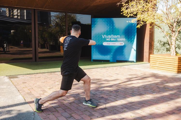 Rotacione o tronco para a esquerda mantendo os braços como estão. As pernas e o quadril devem acompanhar o movimento, com rotação do quadril e flexão dos joelhos.