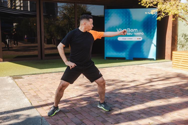 Agora repita a mesma sequência para o lado oposto, estendendo o braço esquerdo lateralmente ao tronco sem dobrá-lo.